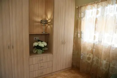 a room with a cabinet with a vase of flowers at Marika Apartment in Athens