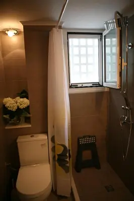 a small bathroom with a toilet and a window at Marika Apartment in Athens