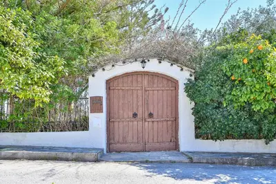a wooden garage door with an orange hedge at Light-filled home with Garden near Beach in Anavissos