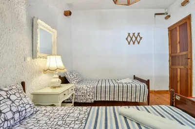 a bedroom with two beds and a table with a lamp at Light-filled home with Garden near Beach in Anavissos