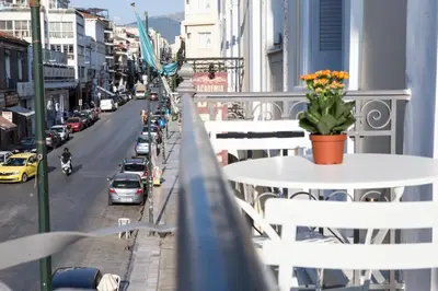 a balcony with tables and chairs and a street with cars at One Three One - In the Heart of Athens in Athens