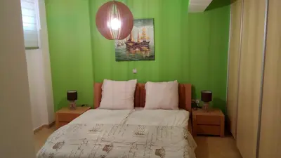 a bedroom with green walls and a bed with white sheets at Luxury Apartment in Ano Glyfada in Athens
