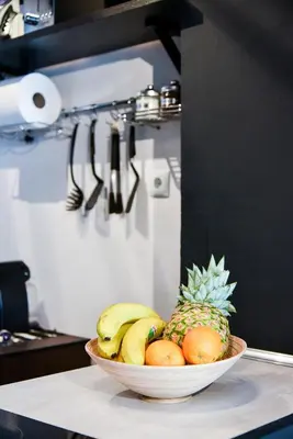 a bowl of fruit on a counter with a pineapple at Home Plus Psirri Apartment in Athens