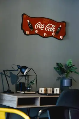 a coca cola sign hanging on a wall at Home Plus Psirri Apartment in Athens