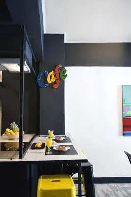 a kitchen with a table and two yellow stools at Home Plus Psirri Apartment in Athens