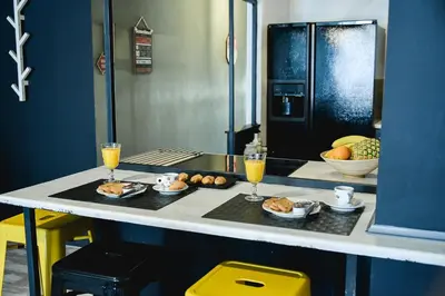 a kitchen counter with two glasses of orange juice and food at Home Plus Psirri Apartment in Athens