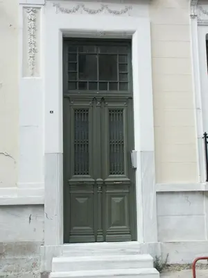 a green door on the side of a building at Athenian house of 1920 in Athens