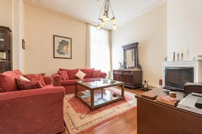 a living room with red couches and a coffee table at Athenian house of 1920 in Athens