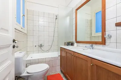 a bathroom with a toilet and a sink and a mirror at Athenian house of 1920 in Athens
