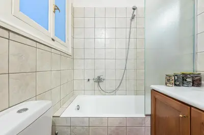 a bathroom with a white tub and a shower at Athenian house of 1920 in Athens