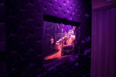 a purple room with a woman sitting in a chair in a mirror at Madison in Athens