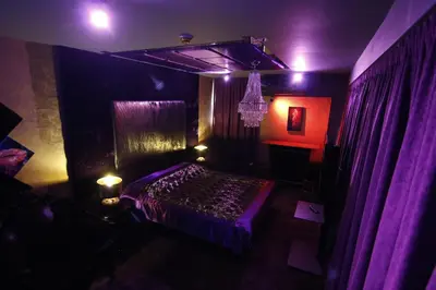 a dark room with a bed with purple lights at Madison in Athens