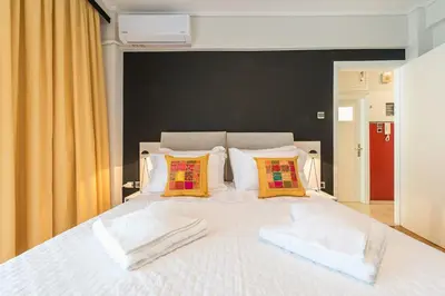 a bedroom with a white bed with two pillows at Seaside Central Apartment in Athens