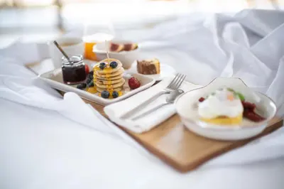a tray of breakfast food on a bed with pancakes and berries at Coco-mat Athens BC in Athens