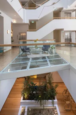 an empty lobby with glass floors and chairs and plants at Coco-mat Athens BC in Athens