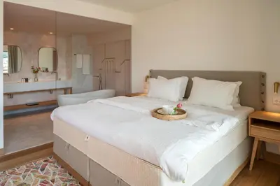 a large white bed with a bowl of fruit on it at Coco-mat Athens BC in Athens