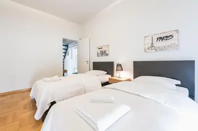 two beds in a bedroom with white sheets at Traveler's Dream 4 brdm Renovated Penthouse in Athens