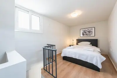 a bedroom with a bed with white walls and a window at Traveler's Dream 4 brdm Renovated Penthouse in Athens