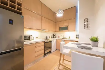 a kitchen with wooden cabinets and a white counter top at Traveler's Dream 4 brdm Renovated Penthouse in Athens