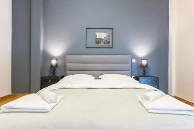 a bedroom with a large white bed with two night stands at Traveler's Dream 4 brdm Renovated Penthouse in Athens