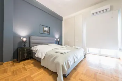 a bedroom with a large bed and a wooden floor at Traveler's Dream 4 brdm Renovated Penthouse in Athens