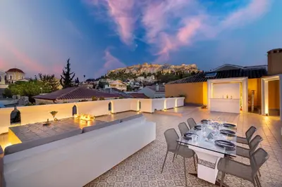 a patio with a table and chairs on a roof at Live Your Myth Under The Acropolis in Athens