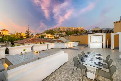 a patio with a table and chairs on a roof at Live Your Myth Under The Acropolis in Athens