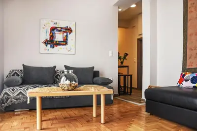 a living room with a couch and a coffee table at Koukaki Edge Penthouse•Acropolis & Filopappou view in Athens