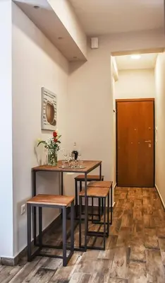 a dining room with a table and two stools at Koukaki Edge Penthouse•Acropolis & Filopappou view in Athens