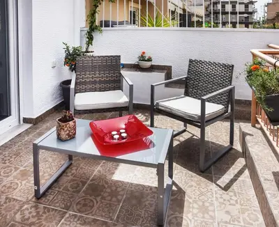 two chairs and a table on a patio at Koukaki Edge Penthouse•Acropolis & Filopappou view in Athens