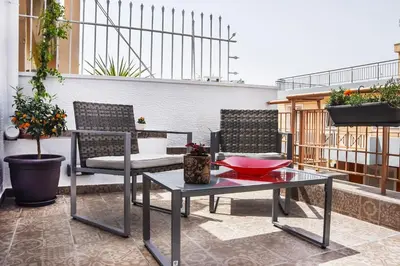 a patio with two chairs and a table on a balcony at Koukaki Edge Penthouse•Acropolis & Filopappou view in Athens