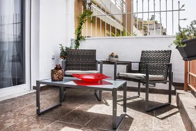 a patio with two chairs and a table on a balcony at Koukaki Edge Penthouse•Acropolis & Filopappou view in Athens