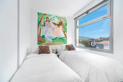 two beds in a white room with a window at Mythos Luxury Suites in Athens