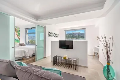a living room with a couch and a tv at Mythos Luxury Suites in Athens