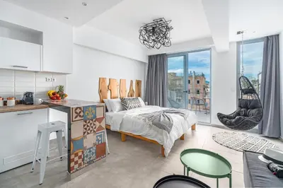 a bedroom with a bed and a kitchen with a window at Mythos Luxury Suites in Athens