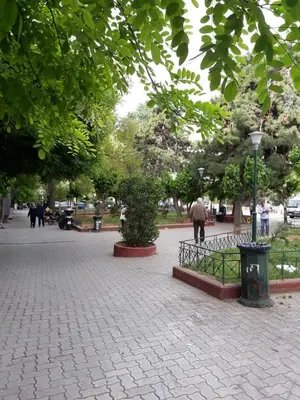a park with trees and people walking on a sidewalk at Fully renovated small & cosy studio in Athens