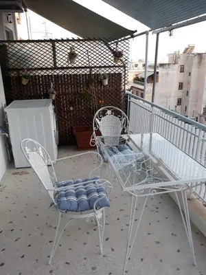 a couple of chairs and a table on a balcony at Fully renovated small & cosy studio in Athens