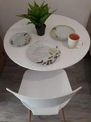 a white table with plates and a plant on it at Fully renovated small & cosy studio in Athens