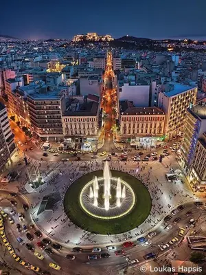 a city at night with a fountain in the middle at Athena's Home, Sunny Balkony 100m from metro! in Athens