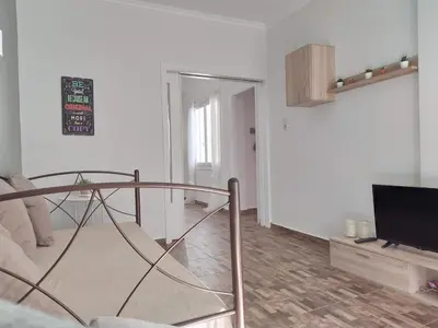 a living room with a glass table and a television at Athena's Home, Sunny Balkony 100m from metro! in Athens