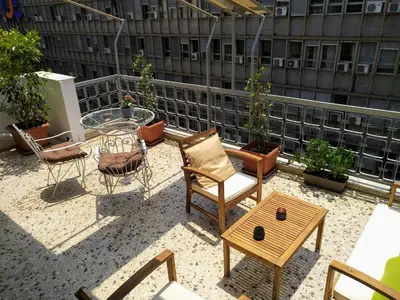 a patio with chairs and a table on a building at Athena's Home, Sunny Balkony 100m from metro! in Athens
