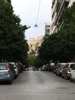 a street with cars parked on the side of the road at Angel Promachos by Acropolis in Athens