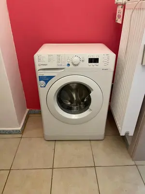 a washing machine in a room with a red wall at Angel Promachos by Acropolis in Athens