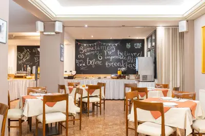 a dining room with tables and chairs and a chalkboard at Hotel Marina in Athens