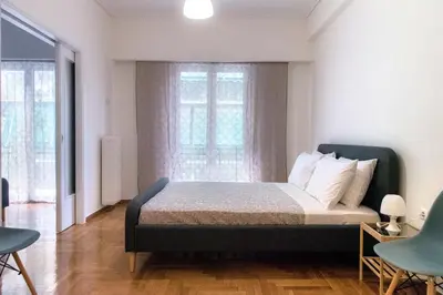 a bedroom with a bed and two chairs and a window at Pnyka Apartment 2 in Athens
