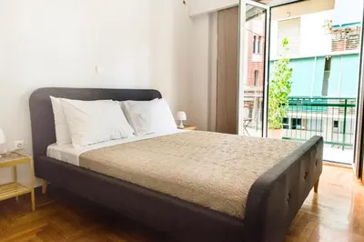 a bedroom with a bed and a large window at Pnyka Apartment 2 in Athens