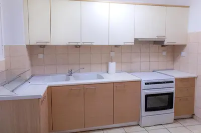 a kitchen with white cabinets and a sink at Pnyka Apartment 2 in Athens