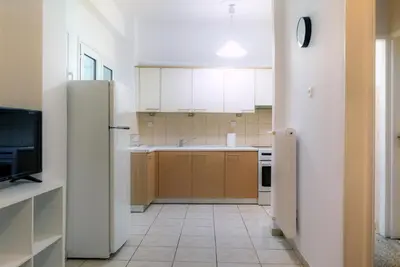 a kitchen with white cabinets and a refrigerator at Pnyka Apartment 2 in Athens