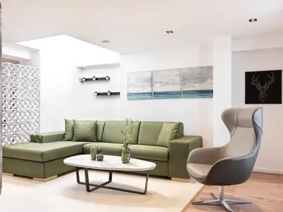 a living room with a green couch and a table at Kolonaki 8 - Design Suites & Lofts in Athens