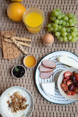 a table with plates of food and grapes and orange juice at Monsieur Didot in Athens